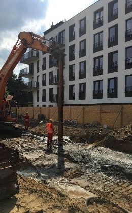 Acélgerenda behelyezése a friss keverékbe kotrógéppel